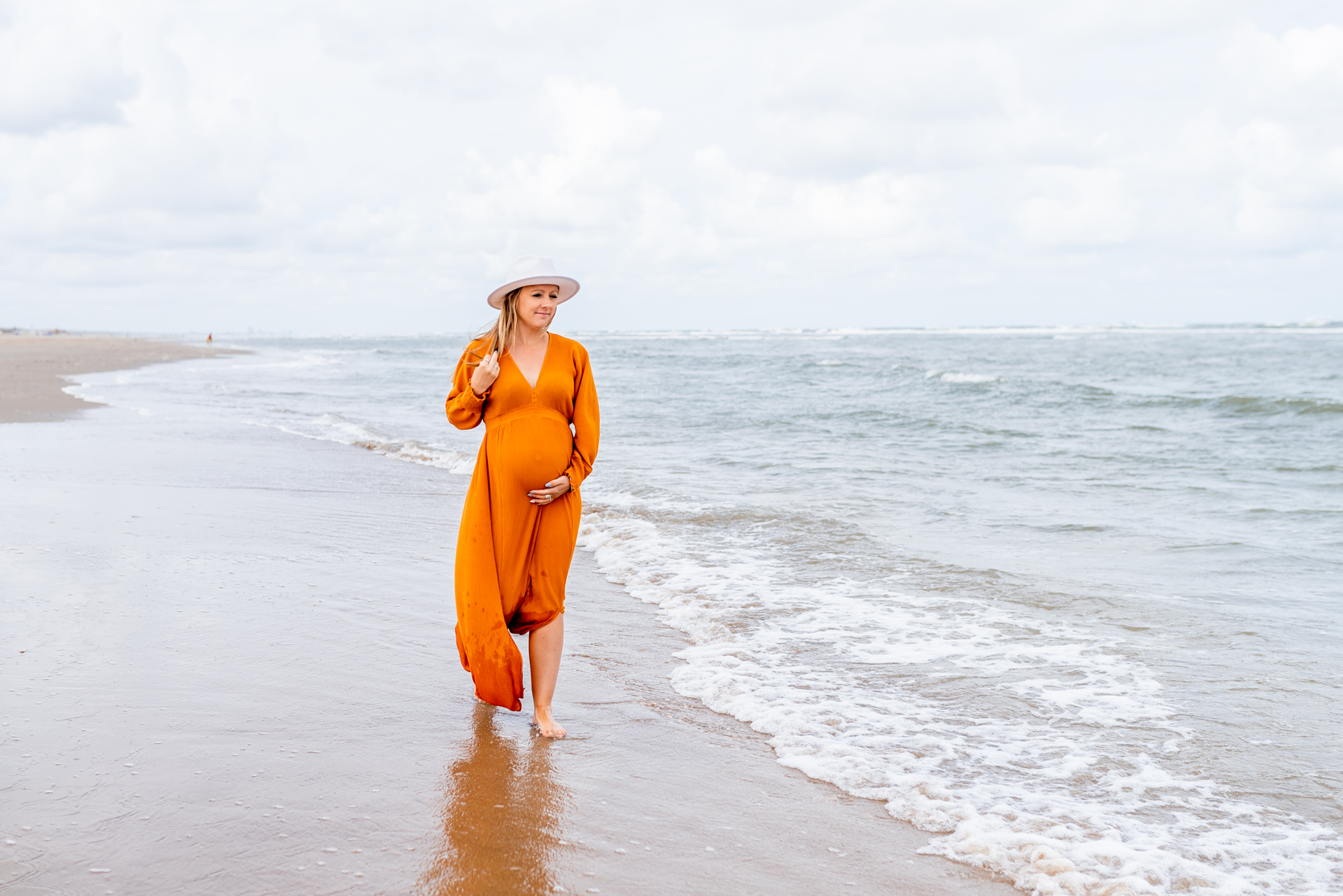 Zwangere moeder loopt naast de zee