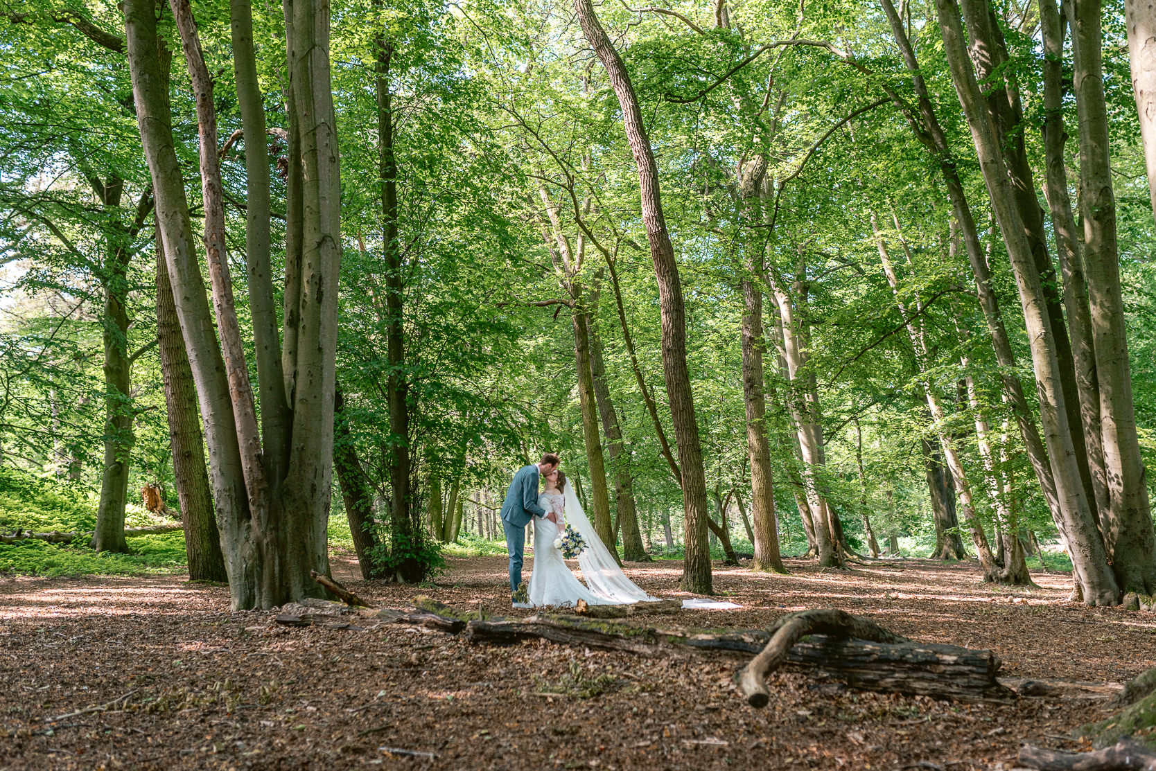 Bruid en bruidegom poseren in bos
