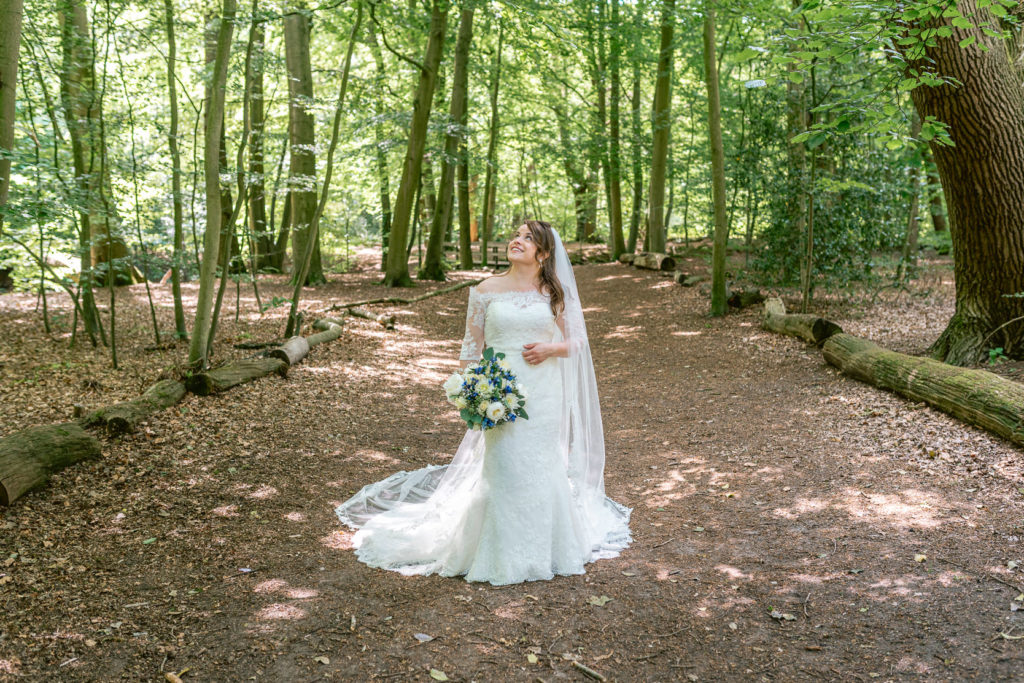 Bruid staat midden in het bos te poseren