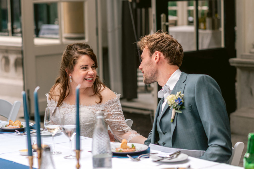 Bruid en bruidegom kijken elkaar liefdevol aan tijdens diner